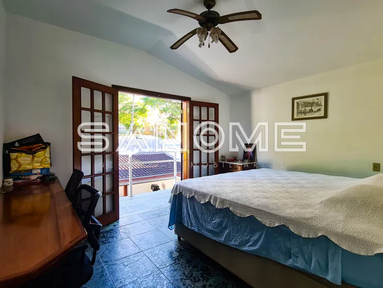 Quarto com cama de casal e acesso à varanda