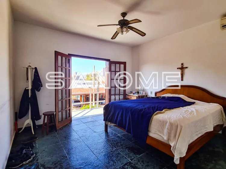 Quarto com cama de casal e varanda com vista externa