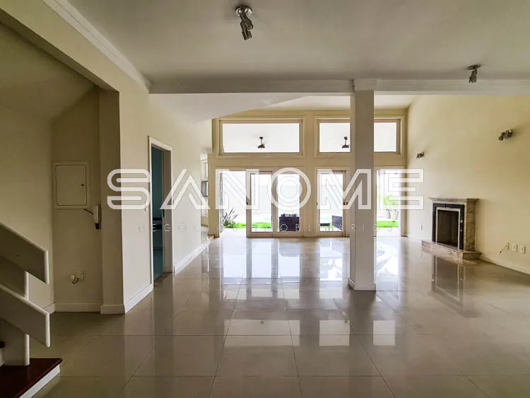 Sala ampla com piso em cerâmica e portas de vidro