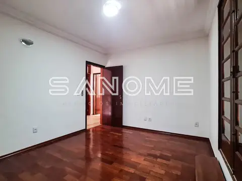 Sala vazia com piso de madeira e porta aberta