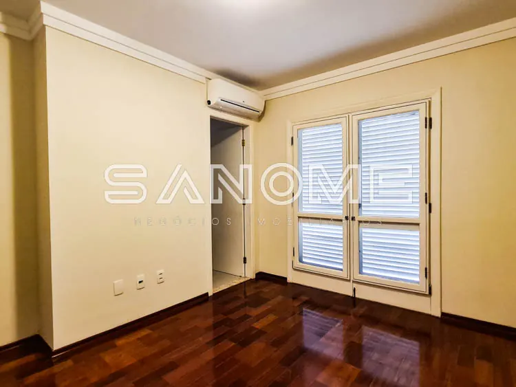 Quarto vazio com piso de madeira e varanda