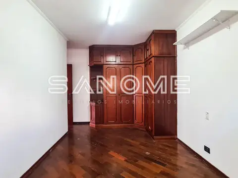 Quarto com guarda-roupa de madeira e piso de madeira