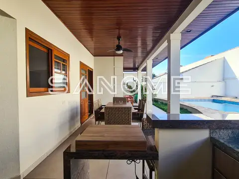 Varanda com mesa, cadeiras e vista para piscina