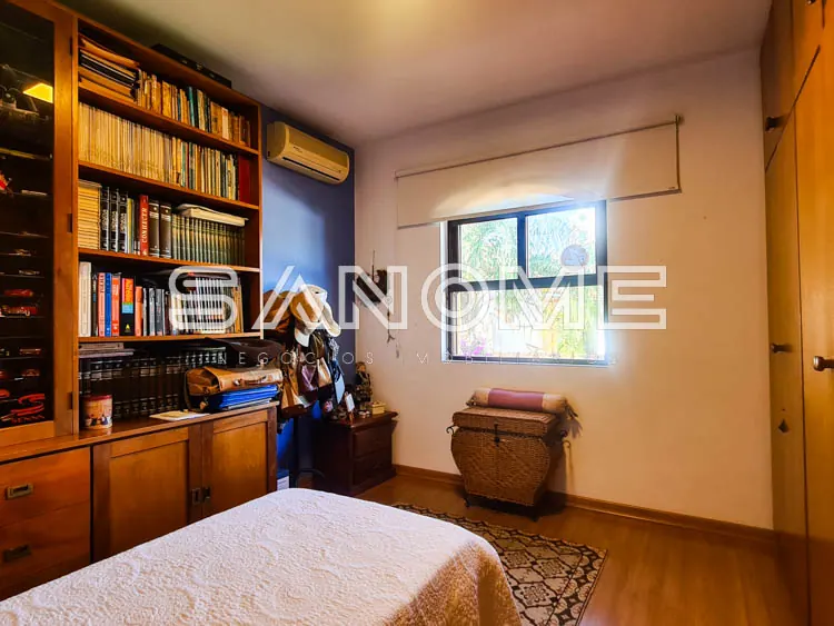 Quarto com cama, estante de madeira e janela