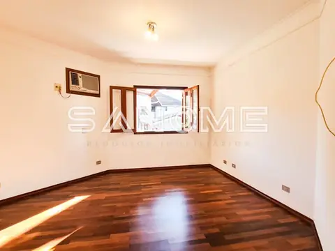 Sala com piso de madeira e janela com vista externa