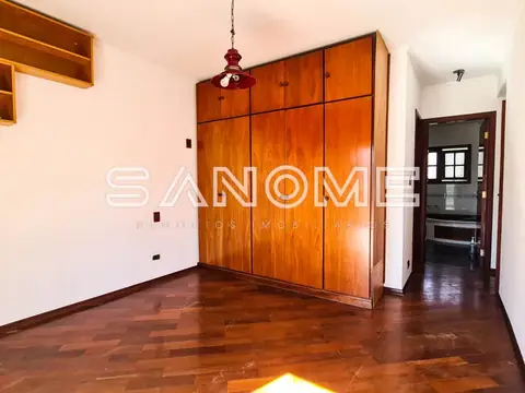 Quarto com guarda-roupa de madeira e piso de taco