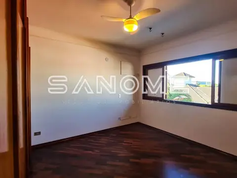 Quarto vazio com piso de madeira e janela ampla