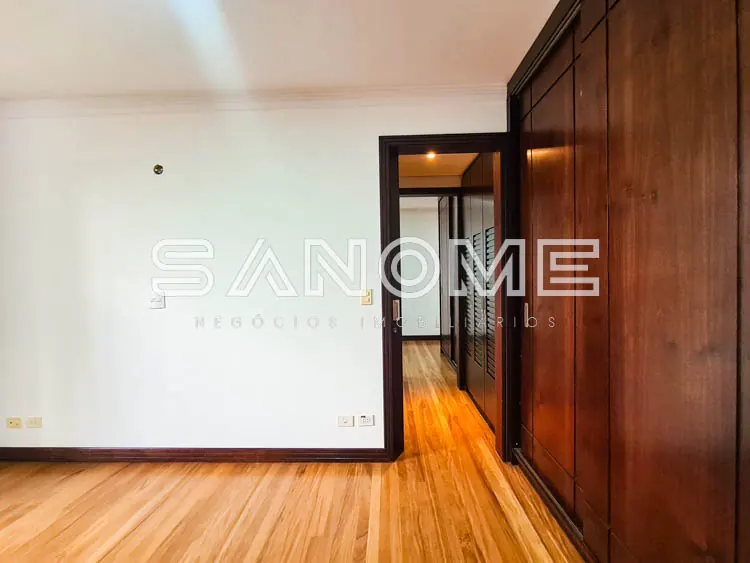Sala vazia com piso de madeira e armário embutido