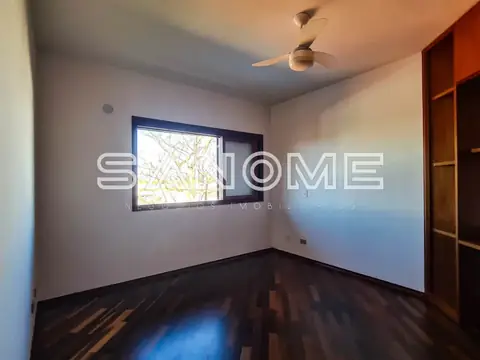 Quarto vazio com piso escuro e janela com vista