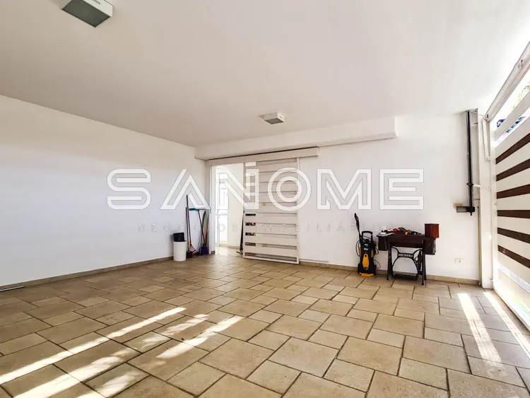 Garagem com piso cerâmico e porta basculante