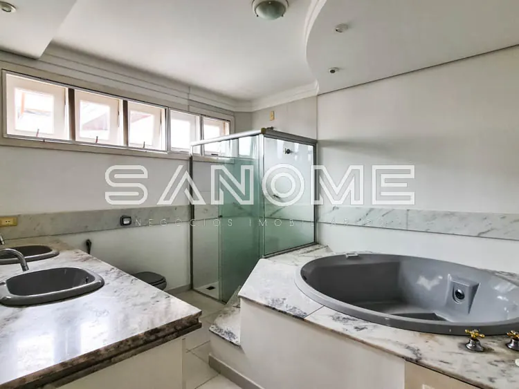 Banheiro com duas pias e box de vidro verde