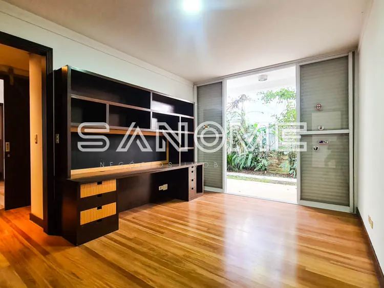 Sala com móvel planejado em madeira e porta para varanda