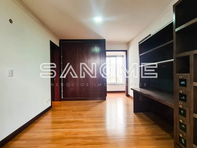 Sala ampla com piso de madeira e móveis planejados