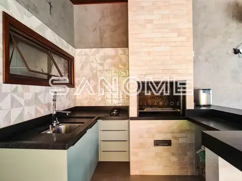 Cozinha com bancada preta e revestimento em cerâmica