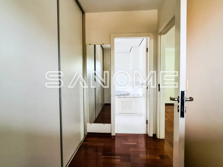 Corredor com piso de madeira e porta de vidro