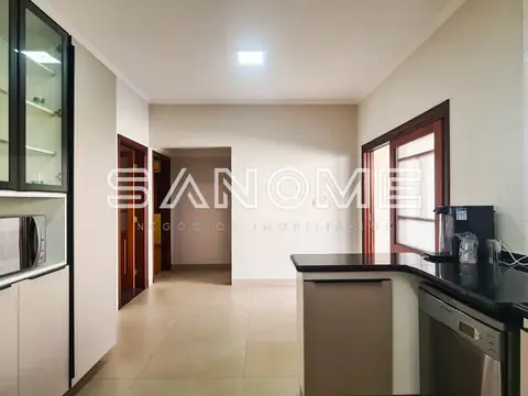 Cozinha ampla com bancada e porta para varanda