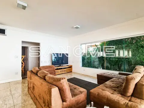 Sala de estar com sofás marrom e painel de TV