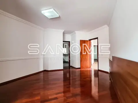 Sala ampla com piso de madeira e porta vermelha