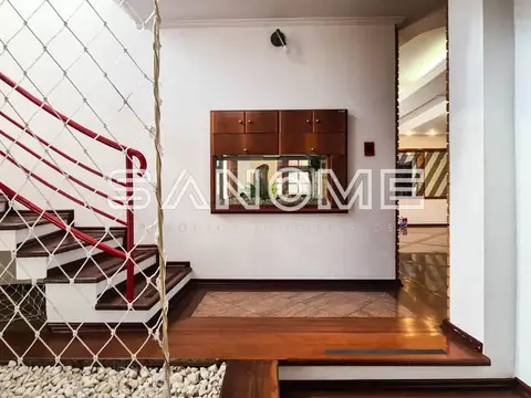 Sala com escada, painel de madeira e espelho