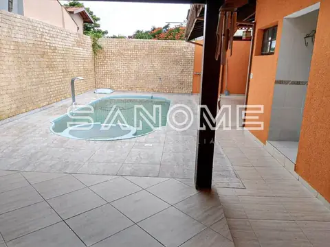 Área externa com piscina redonda e piso em cerâmica