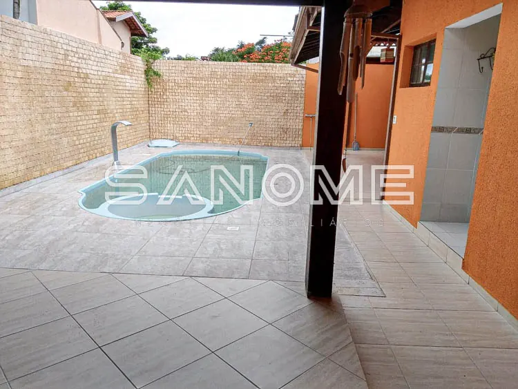Área externa com piscina redonda e piso em cerâmica