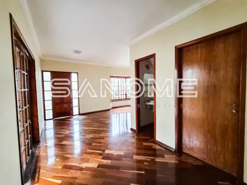 Sala ampla com piso de madeira e portas de madeira maciça