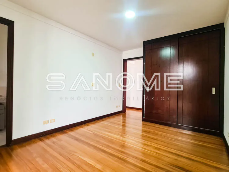 Sala com piso de madeira e guarda-roupa embutido