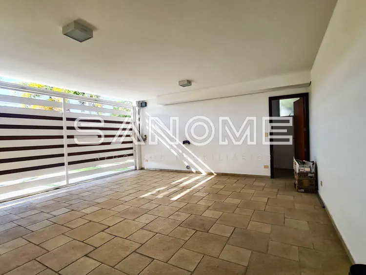 Sala vazia com piso em cerâmica e garagem com basculante