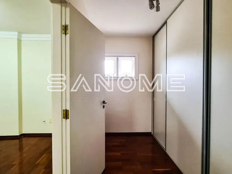 Corredor com portas de armário embutido e piso de madeira