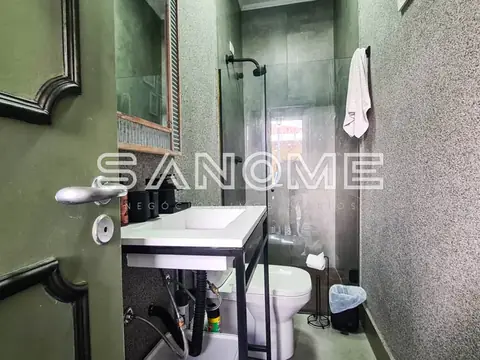 Banheiro com pia, espelho e chuveiro com box