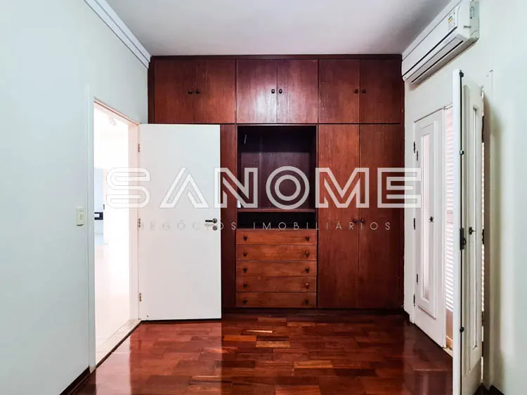 Quarto com guarda-roupa em madeira e piso de madeira