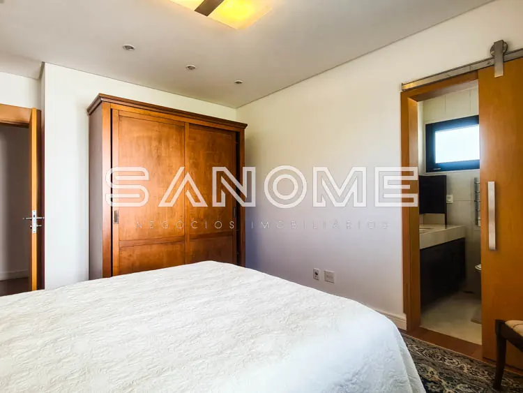 Quarto com cama de casal e guarda-roupa em madeira