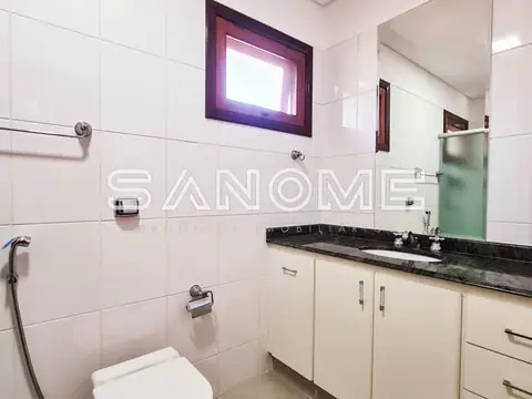 Banheiro com bancada, espelho e azulejos brancos