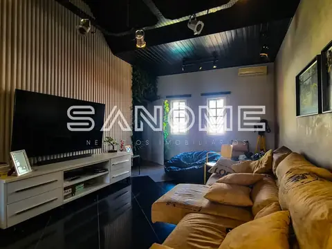 Sala de estar com sofá marrom e painel de TV
