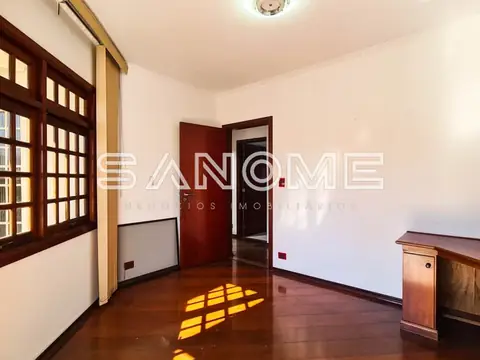 Sala com piso de madeira e porta vermelha