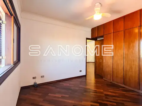 Quarto com guarda-roupa de madeira e piso em madeira