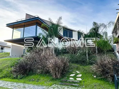 Casa moderna com fachada de vidro e vegetação