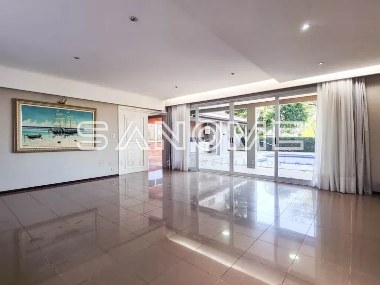 Sala ampla com piso polido e grandes janelas