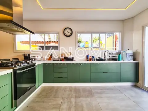 Cozinha planejada com armários verdes e bancada branca