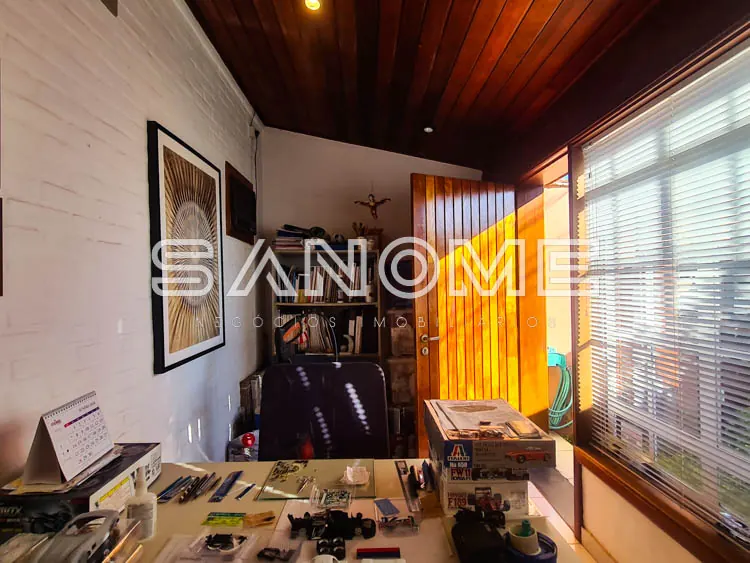 Sala de trabalho com mesa, equipamentos e janelas com vista