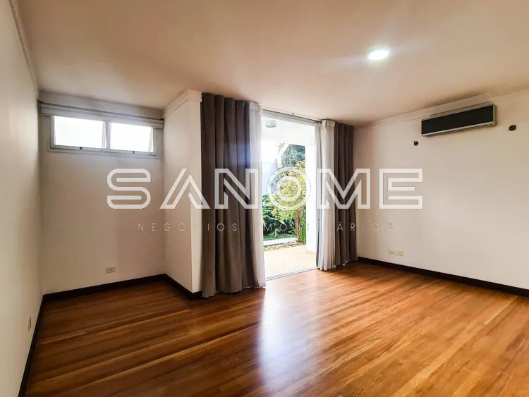 Sala ampla com piso de madeira e acesso ao jardim
