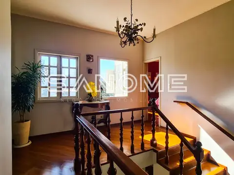 Escada de madeira com janelas e lustre no patamar