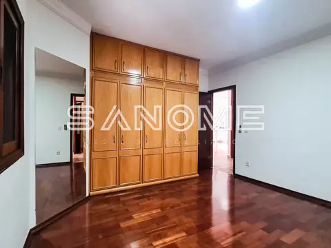 Quarto com guarda-roupa de madeira e piso de cerâmica