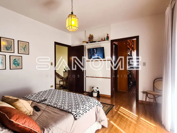 Quarto com cama de casal e portas de madeira escura