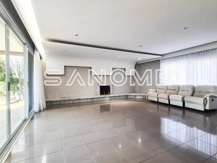 Sala ampla com sofá cinza e piso polido