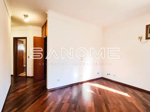 Sala vazia com piso de madeira e porta de entrada