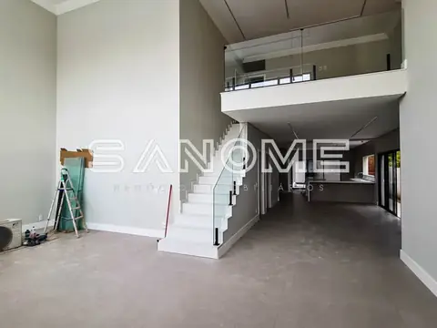 Sala com pé direito duplo e escada branca central
