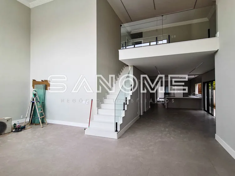Sala com pé direito duplo e escada branca central