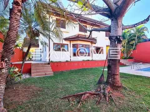 Fachada de casa com área externa e árvore frondosa
