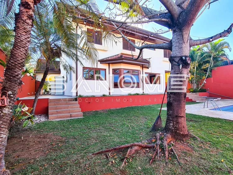 Fachada de casa com área externa e árvore frondosa